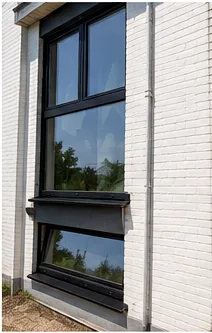 Châssis aluminium : fenêtre à cadre sombre installée sur une façade en briques claires.